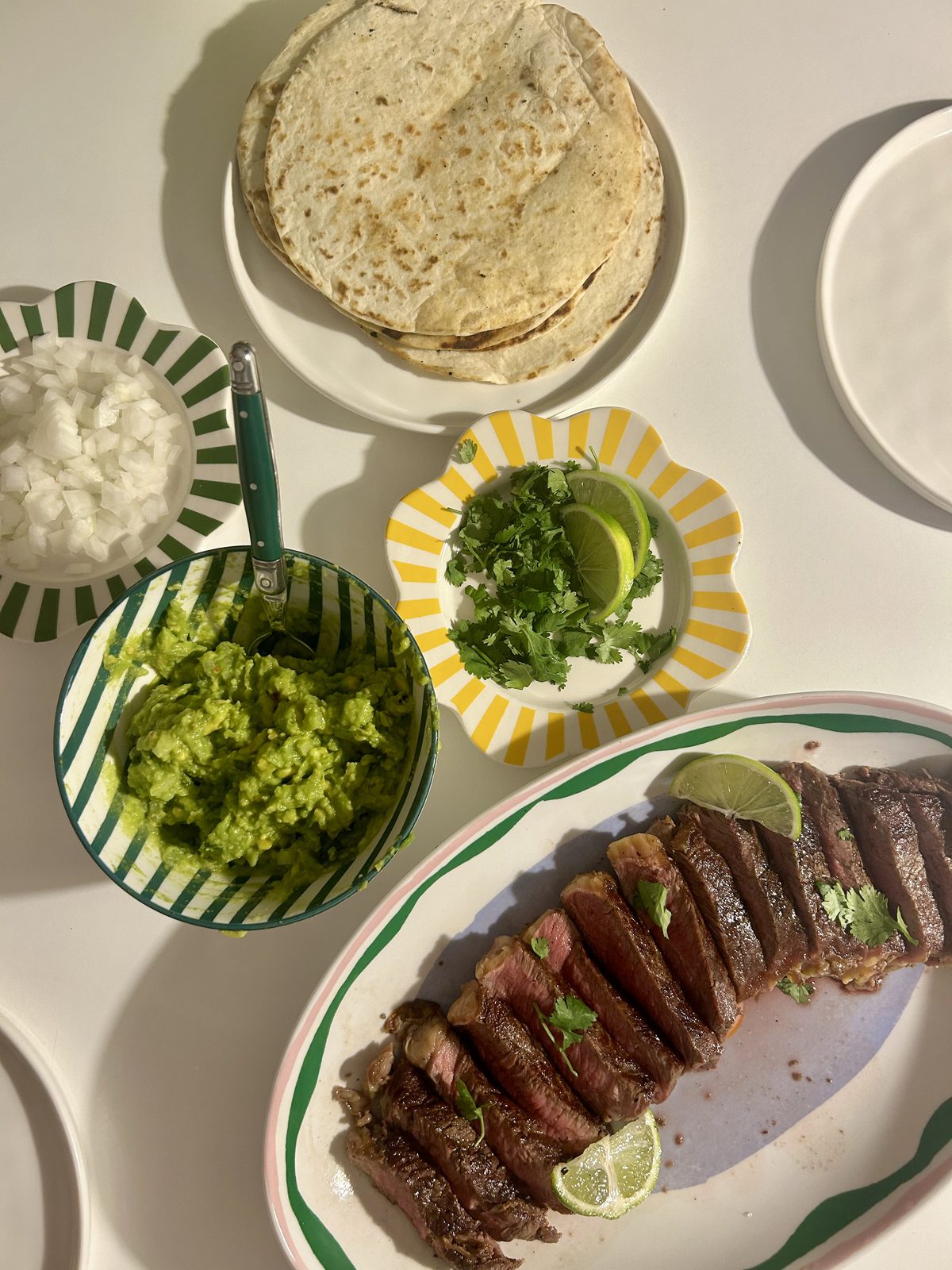Sliced steak tacos with homemade guacamole, onion and coriander